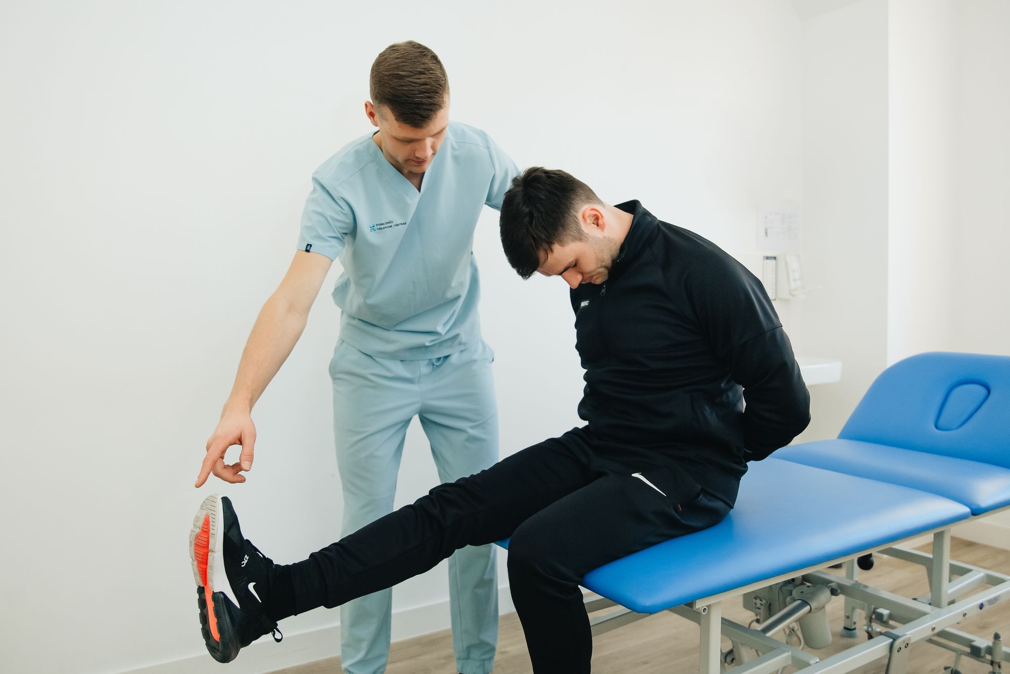 Physical therapist assisting a patient with leg exercises